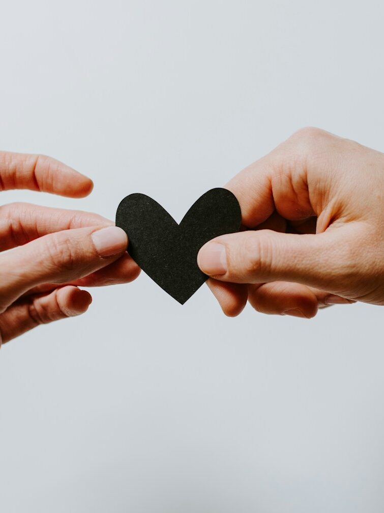 two person holding papercut heart